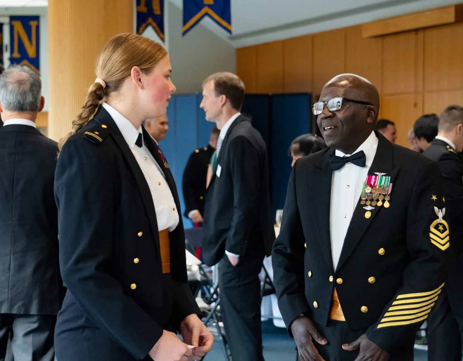 A man and young woman in uniform having a discussion