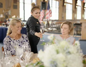 A server serving food to guests at a table