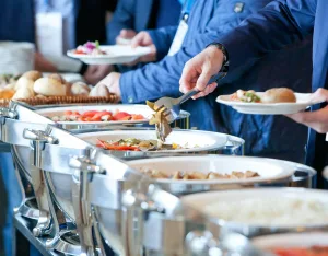 Guests taking food from a buffet at an event