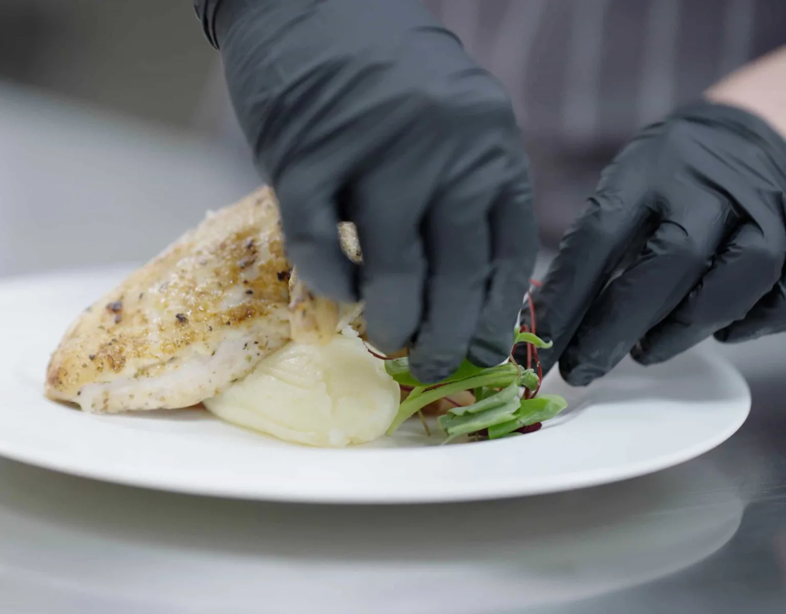Closeup of a chef's hands preparing an entrée