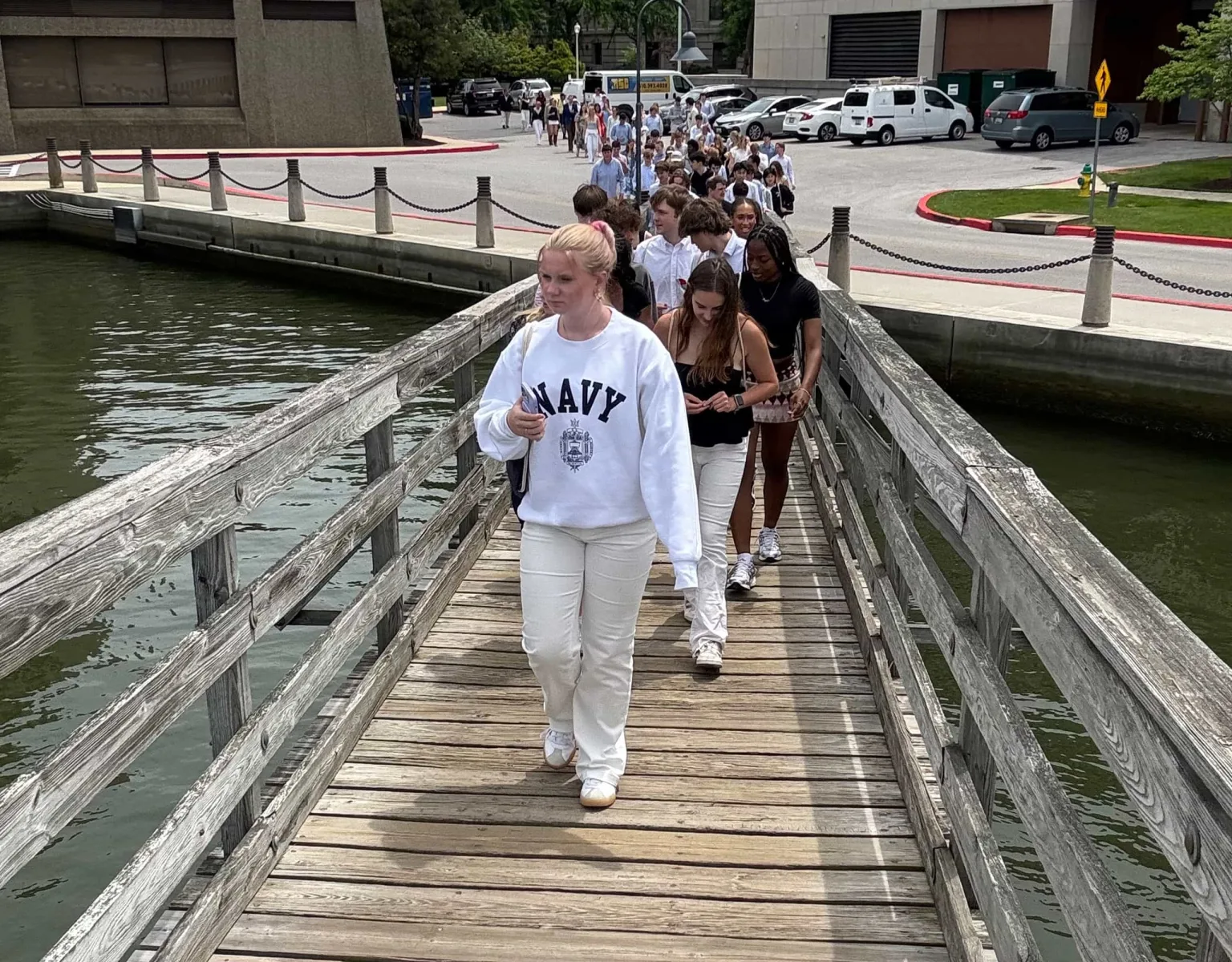 A group of students crossing a bridge over water