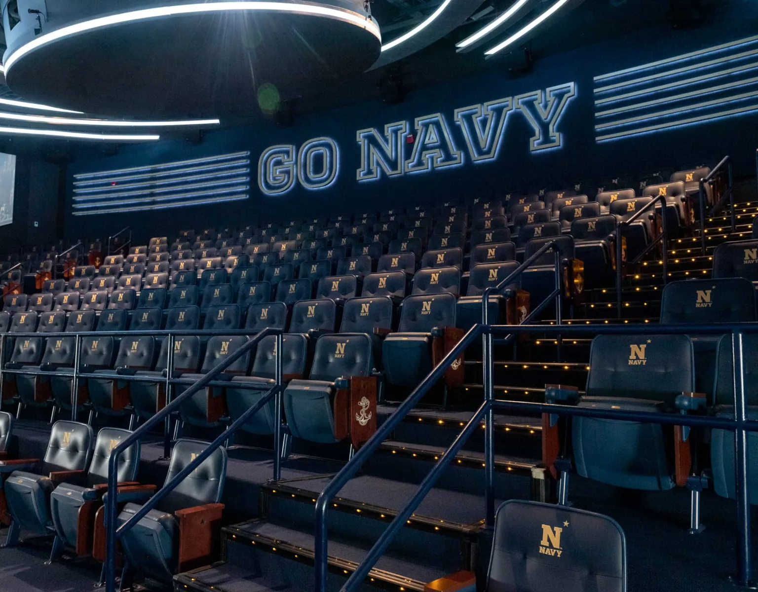 Stadium style seating with the Navy logo on the headrest of each chair