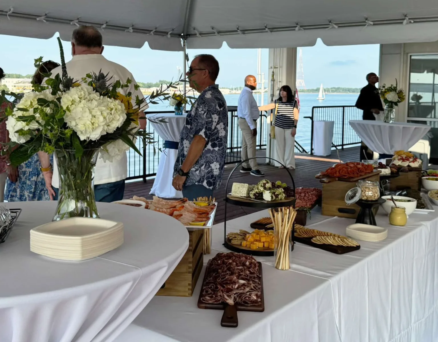 Guests standing near a buffet at an outdoor event